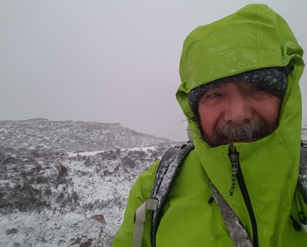 Chris Townsend (author) in green Patagonia Ascenionist Jacket with hood up