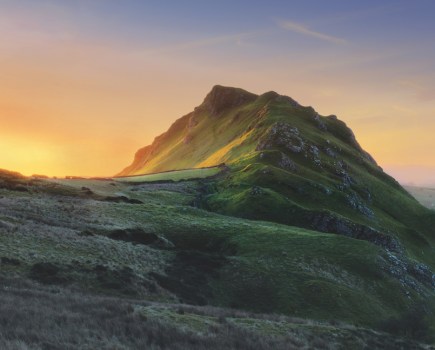 Misty, muticoloured sunrise sky behind Chrome Hill, Peak District