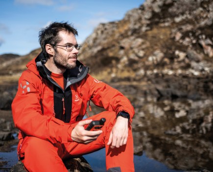 Man wearing red Haglofs L.I.M series Z/T Mountain GTX Pro Waterproof Shell pant and jacket