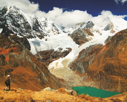 Green lake below snow capped mountain in Cordiliera Huayhuash, Peru, South America