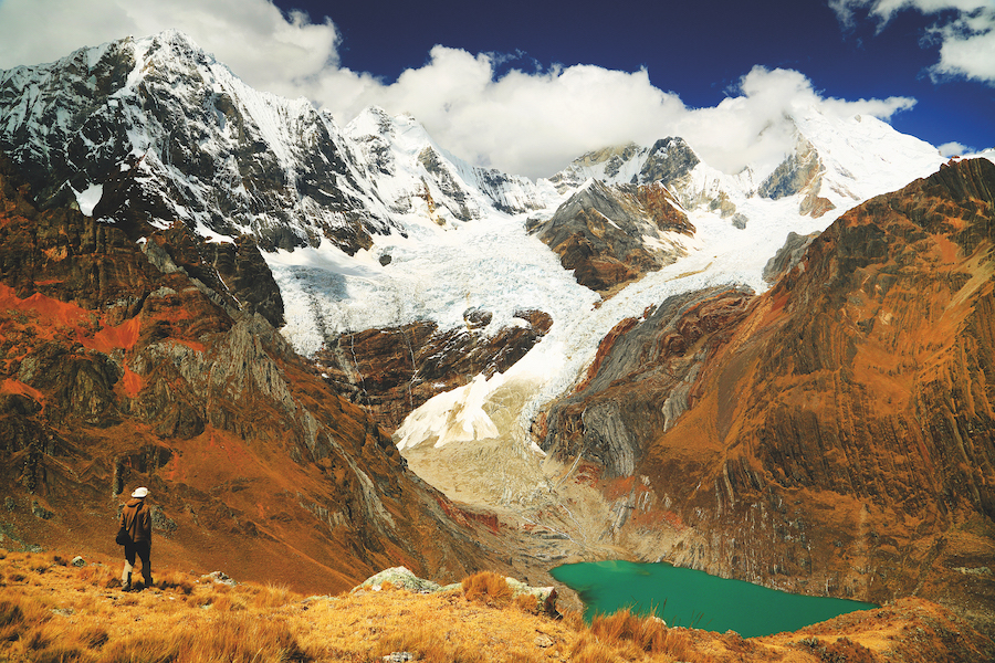 Green lake below snow capped mountain in Cordiliera Huayhuash, Peru, South America