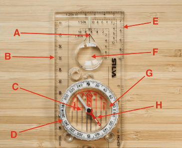A compass laying flat on a wooden table