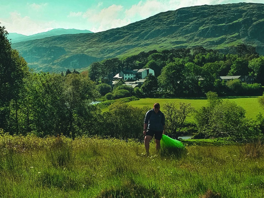 Grace dragging a kayak across a field