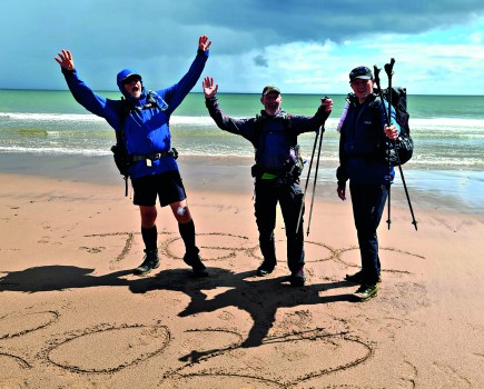 group on a beach with tgo 2022 written in the sand