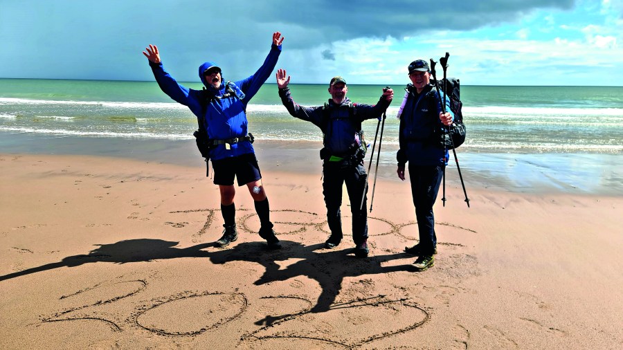 group on a beach with tgo 2022 written in the sand