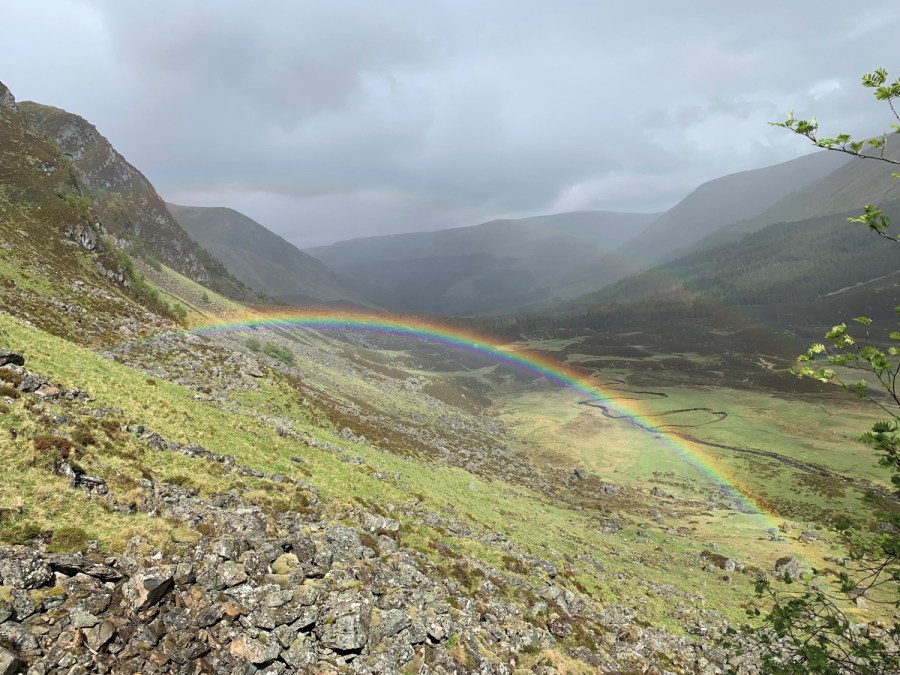 Rolling hills with a rainbow connecting across to either side