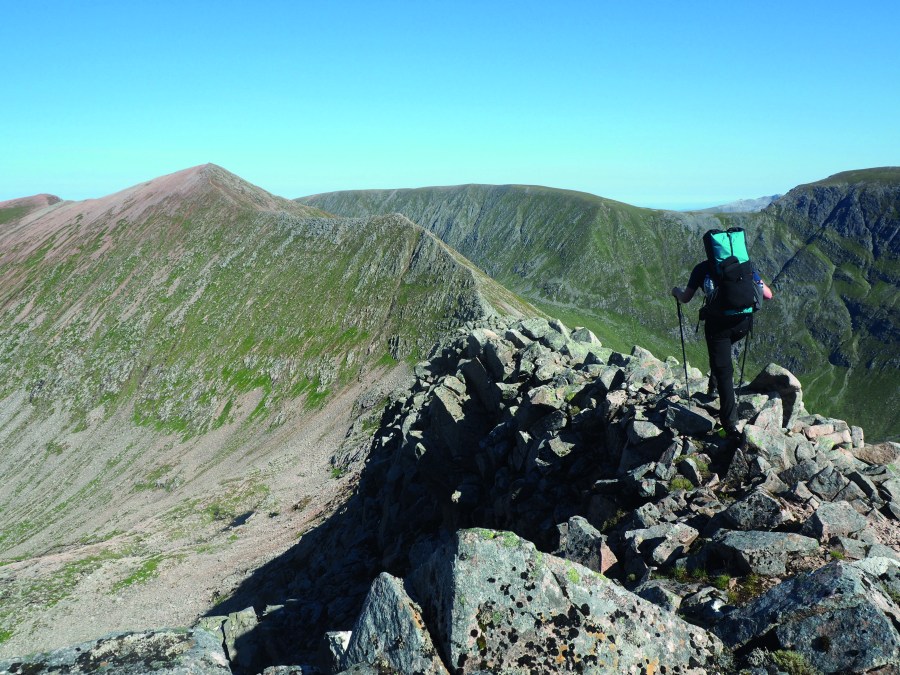 A hiker on the Lochaber traverse wearing a mid-range pack, one of the many types of backpack for hiking.
