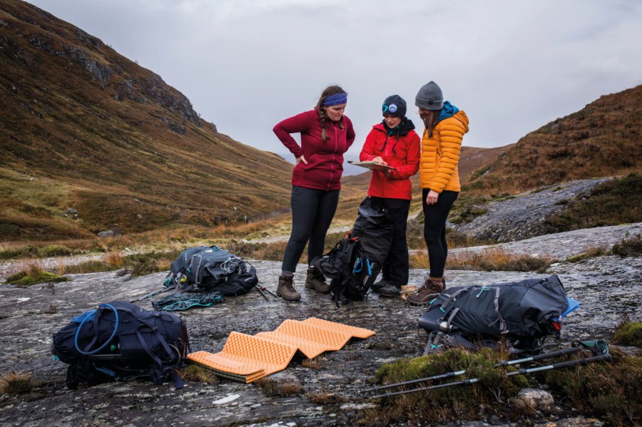 A group of women at their campsite looking at a map planning a route