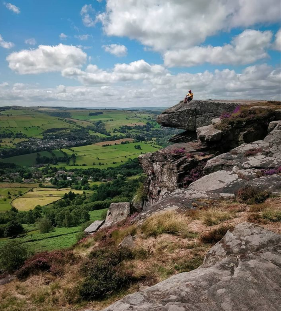 A hiker sitting on Baslow Edge