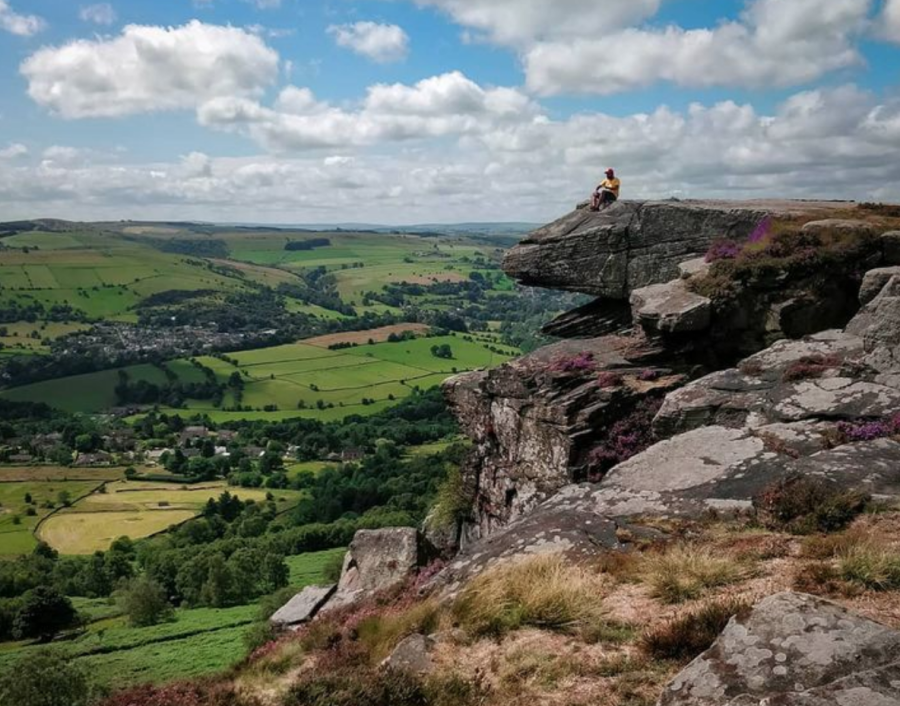 A hiker sitting on Baslow Edge