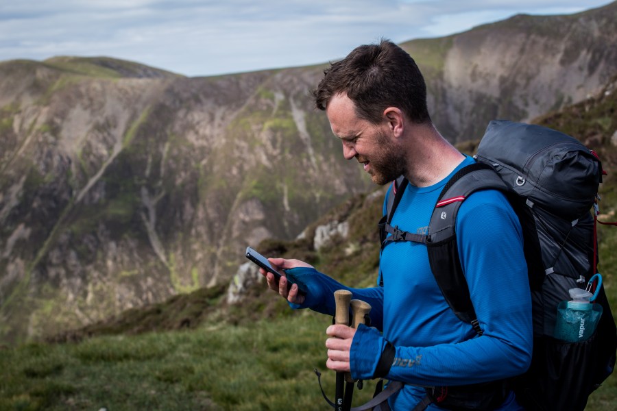 A hiker using a hiking app instead of Google Maps for hiking navigation.