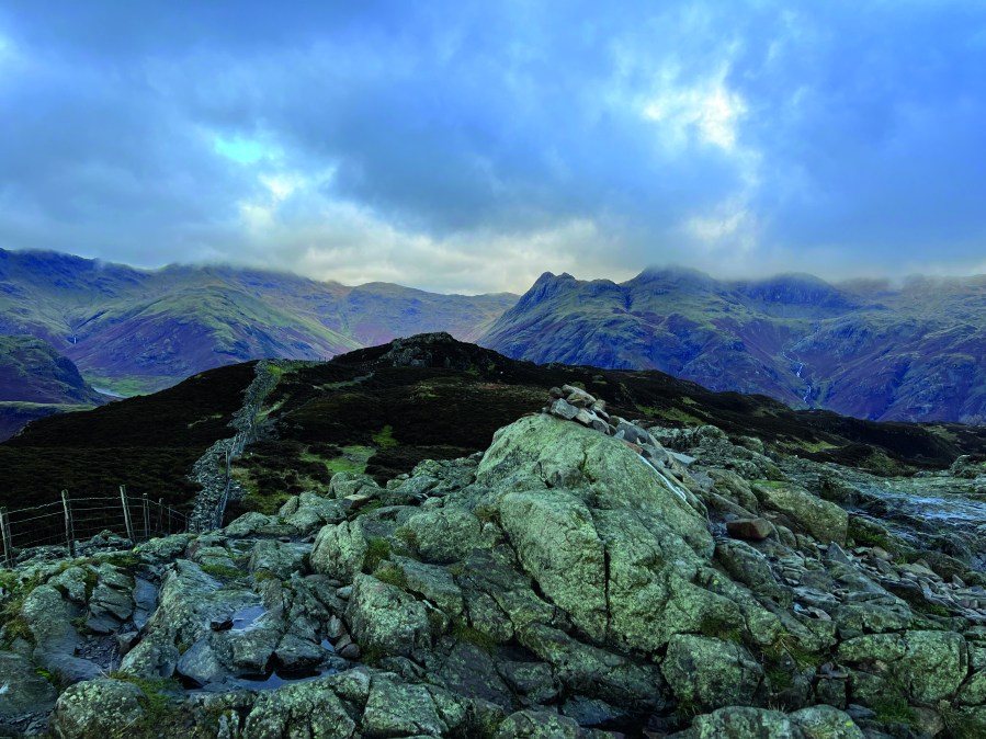 The Langdale Pikes peek from below the clouds as viewed from Lingmoor Fell summit