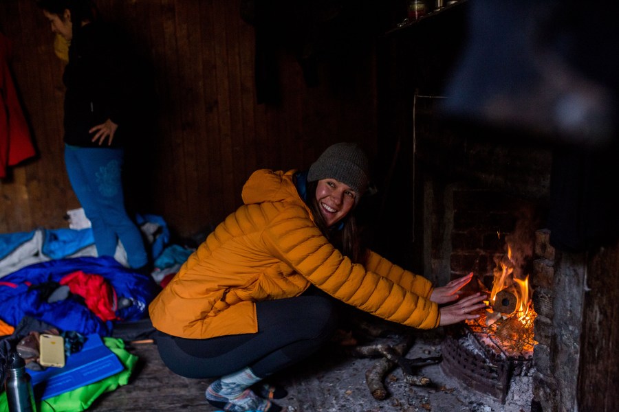 Iona Andean warming her hands by the bothy fire.Credit: Jessie Leong