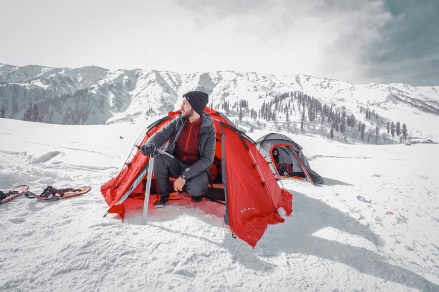 man camping on snow_how to winter wild camp_pexels-syed-qaarif-andrabi