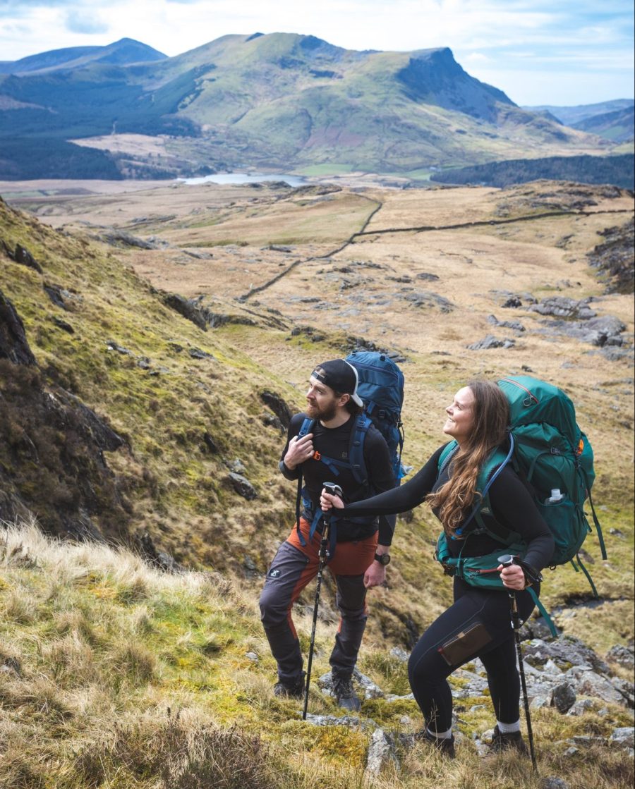 two hikers, one using hiking poles, in Eryri/Snowdonia