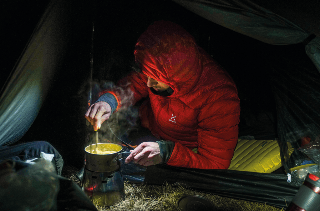 Rich Hartfield cooking in camp in the Cairngorms. Credit: David Lintern