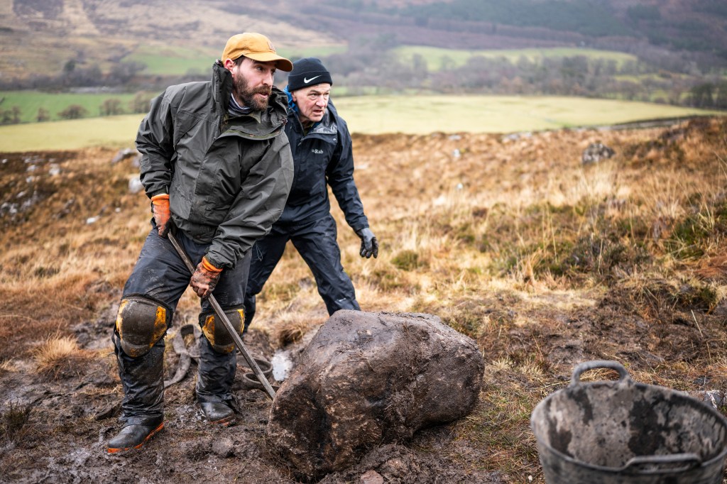 Ewan Watson and a volunteer moving a stubborn boulder