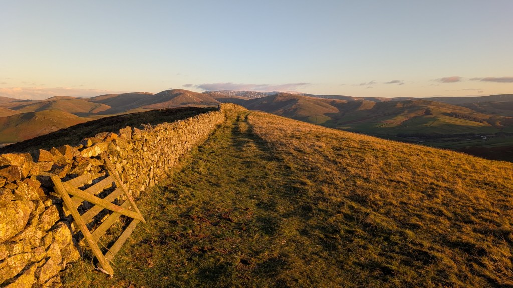 View of the Cheviot Hills from the summit of Wideopen Hill at sunset