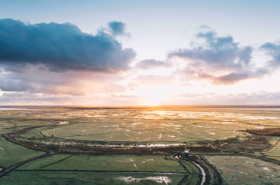 The watery landscape of Halvergate Marshes in the Broads glistens in the sun. Credit - Tom Barrett
