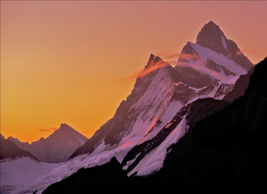 BERNESE ALPS, SWITZERLAND : dawn view of the FINSTERAARHORN (4274m./14,022ft) - the highest peak in the Bernese Alps - seen from the north. The subsidiary peak with the cloud veils is the Agassizhorn (3953m.) 
