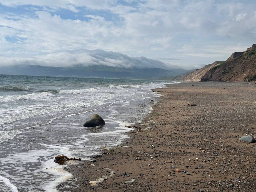 The five-mile-long stretch of beach along Ramsey Bay, Snaefell under Manannan's Cloak in the distance. Credit: Francesca Donovan