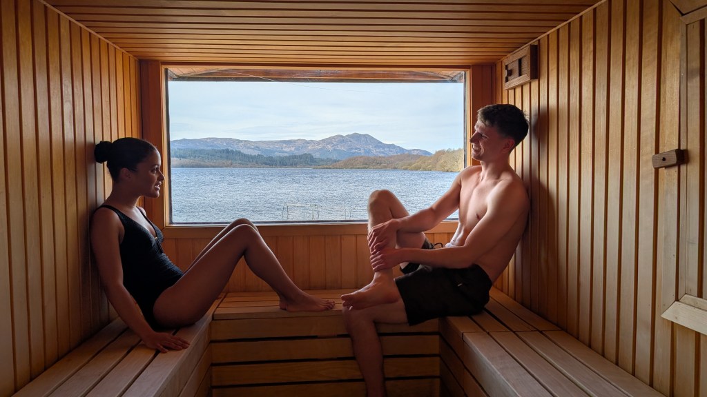 DPS_A man and a woman in Venachar Lochside Sauna with a view of Loch Venachar and Ben Venue. Credit: Turnbulldouglas