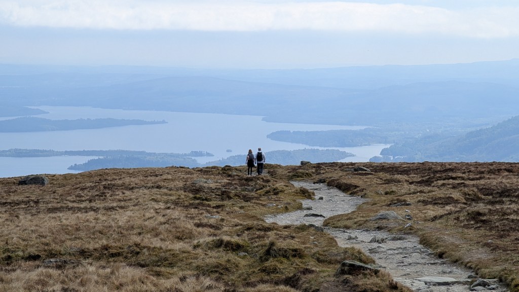 Hikers heading down Ben Lomond on the Mountain Path with Loch Lomond before them. Credit: Julia Clarke