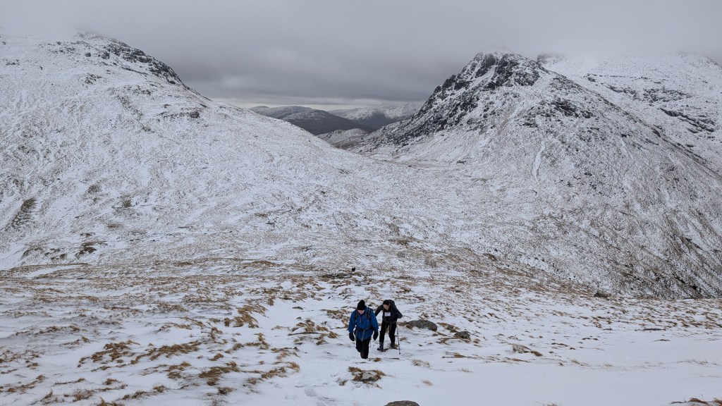Two hikers heading up Beinn Ime with the Cobbler (R) and Beinn Narnain (L) in the background