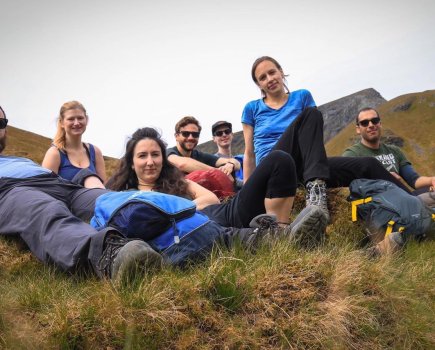Group of walkers lying on a grassy incline