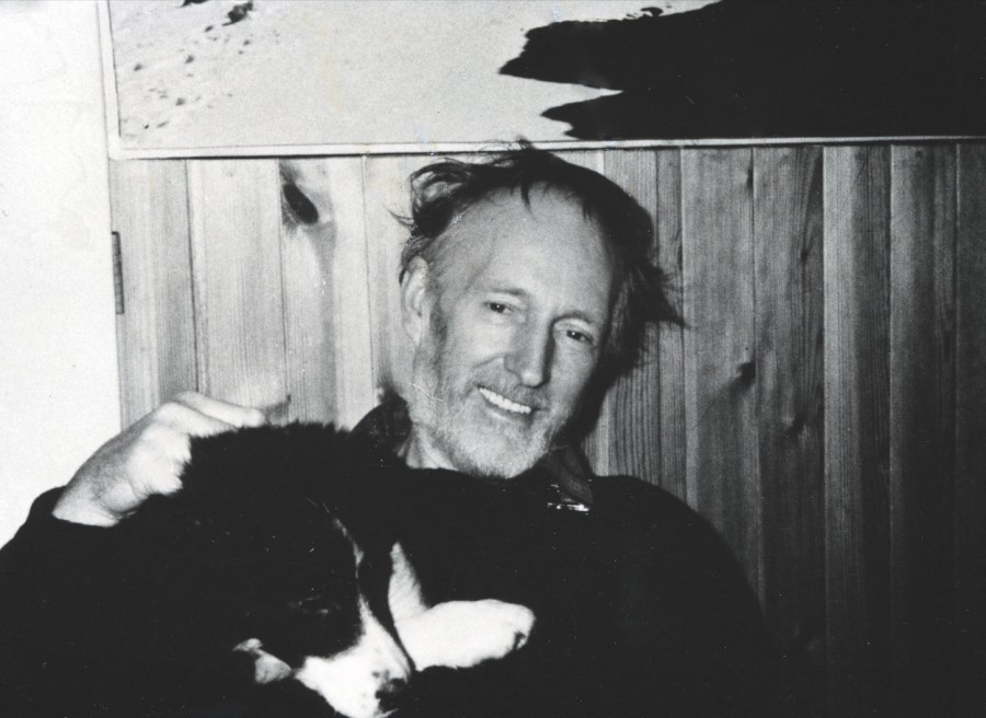 Black and white capture of MacInnes holding a border collie dog