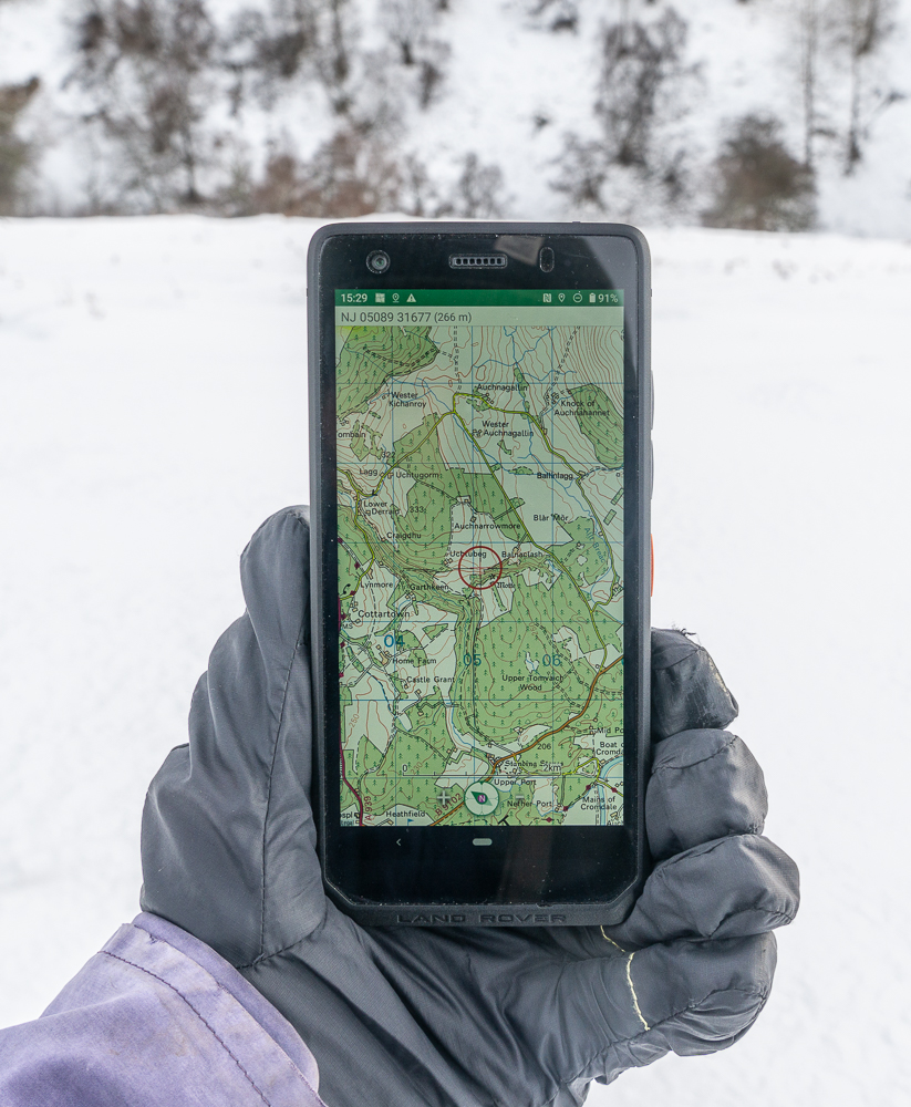 Land Rover Explore R Outdoor phone, displaying map, held by black glove