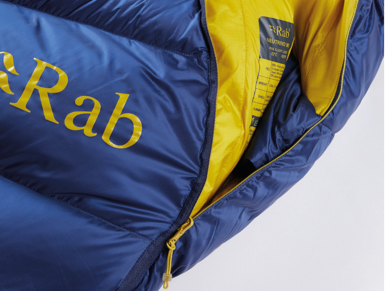 Close up of the front main zip of a Rab Neutrino sleeping bag, blue and yellow