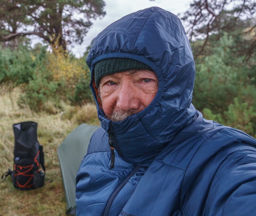 Chris Townsend wears the Rohan Helios jacket in Blue whilst hiking, with hood and zipper up.